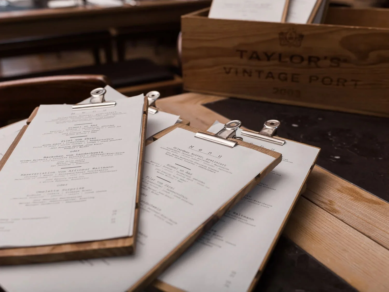 Menus on wooden clipboards resting on a restaurant table.